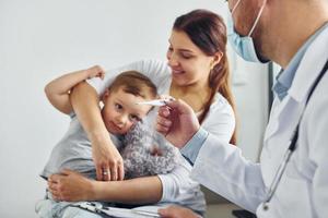 dem Kind helfen. Zwei Ärzte in weißen Kitteln arbeiten in der Klinik zusammen foto