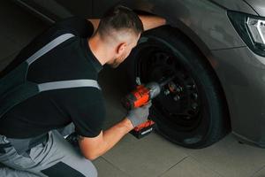 Ein beschäftigter Mann in Uniform arbeitet tagsüber im Autosalon foto