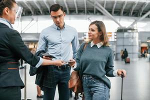 Dokumentenkontrolle am Eingang. junges paar ist zusammen am flughafen foto