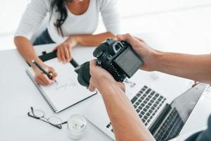 Fotograf bei der Arbeit. zwei junge freiberuflerinnen tagsüber drinnen im büro foto