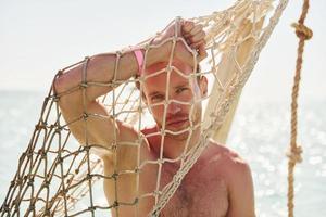 warmes Wetter. junger europäischer mann hat urlaub und genießt die freizeit am strand des meeres foto
