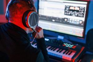 Typ hat einen Job mit Projekt und mischt Musik drinnen im Studio foto