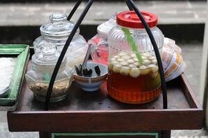 wedang ronde tangyuan, ein traditionelles getränk, das von den chinesen eingeführt und von den holländern benannt wurde, wird normalerweise mit einer tragestange verkauft. foto