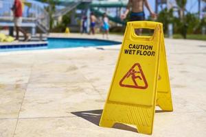 Gelbes Warnschild für nassen Boden im Sommertag, Nahaufnahme foto