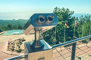 optisches Gerät, Fernglas mit Panoramablick auf die Berge. Besichtigung der Umgebung aus großer Höhe, lokale Schönheit. vom Berg aus zusehen foto