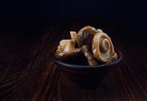 Köstliche schöne eingelegte Pilze in einer Tonschale auf einem Holztisch. gesalzene Pilze. rustikales essen. foto