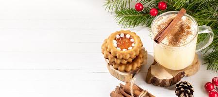 weihnachtsbreites banner mit traditionellem getränk eierlikör und ingwerplätzchen auf weißem holztisch. Platz kopieren. foto