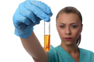 wissenschaftler, der im labor arbeitet, untersucht ein reagenzglas mit flüssigkeit. medizinisches Konzept. foto