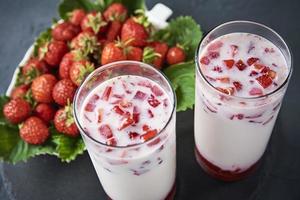 Erdbeermilch-Smoothie im Glas auf dunklem Hintergrund foto