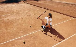 in der Nähe des Netzes. Tennisspielerin ist tagsüber auf dem Platz foto