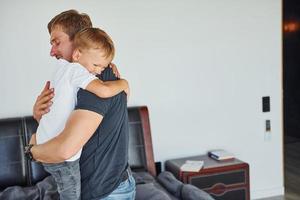 einander umarmen. Vater und Sohn sind zusammen zu Hause foto