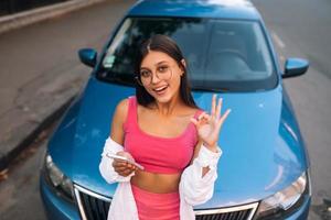 Frau mit Handy in der Nähe des Autos auf der Straße foto