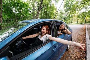 Zwei Freundinnen albern herum und lachen zusammen in einem Auto foto