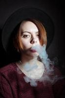 Porträt eines jungen Mädchens im Rauch von Zigaretten foto