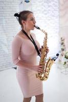 schönes Mädchen, das Saxophon spielt foto