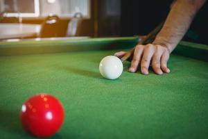 Schließen Sie den Snooker-Spieler der Hand und den weißen und roten Snooker-Ball oder den Pool auf dem Snooker-Tisch. das Wettkampf-Snooker-Spiel, Wette. Indoor-Sportkonzept. foto