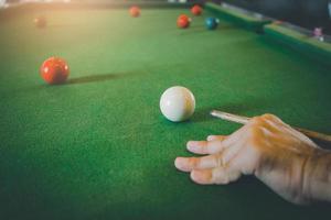 Schließen Sie den Snooker-Spieler der Hand und den weißen und roten Snooker-Ball oder den Pool auf dem Snooker-Tisch. das Wettkampf-Snooker-Spiel, Wette. Indoor-Sportkonzept. foto