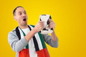 fußballfan mit einem deformierten zerknitterten ball und mit der flagge der vae foto