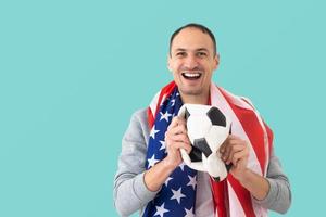 männlicher fußballfan mit einem zerknitterten ball und mit der usa-flagge foto