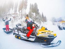 porträt der frau auf dem schneemobil. konzept des schneesports und des gesunden lebensstils foto