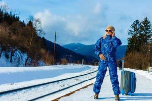 Frau in Skianzügen steht in der Nähe der Eisenbahn foto