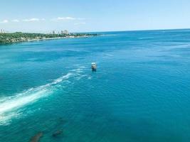 Eine Yacht mit Touristen schwimmt mit weißem Schaum auf dem Meer. Yacht mit Menschen auf hoher See. Reise in ein tropisches Land. Strandresort foto