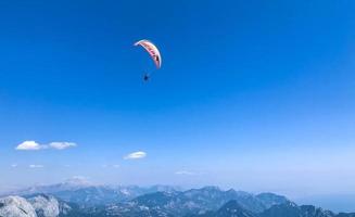 Gleitschirmfliegen in einem heißen Land. Fallschirmspringen vom Berg, Reisen durch die Wolken. heller Farbfallschirm in weißen Wolken. Freizeit foto