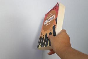 west java, indonesien im juli 2022. eine hand hält einen roman namens rapijali second edition, der von der berühmten schriftstellerin dee lestari geschrieben wurde foto