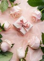 Draufsicht auf rosa Rosen und Geschenkbox auf rosa Tüllhintergrund. foto