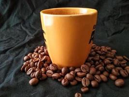 Kaffeetasse und Kaffeebohnen auf schwarzem Hintergrund