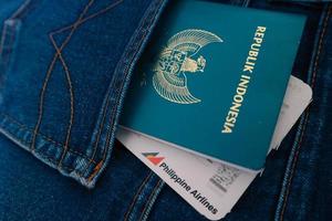 indonesien im juli 2022. ein indonesischer pass und eine bordkarte der philippines airlines in einer jeanstasche. foto