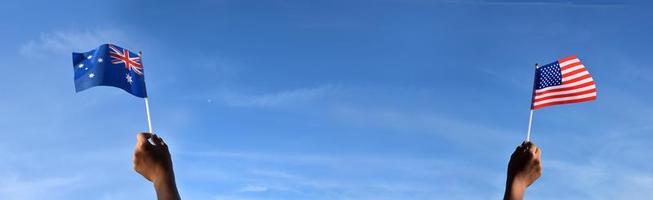 amerikanische nationalflagge und australisches halten in der hand gegen bluesky, weicher und selektiver fokus. foto