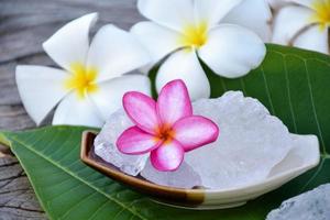 Weicher Fokus von lila Plumeria-Blume und weißem Alaun-Würfel auf Weidenkorb-, Spa- und Hautpflegekonzept. foto