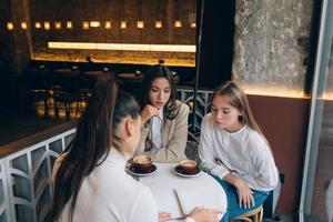 eine Gruppe von Freundinnen in einem Café, die an einem Projekt arbeiten foto