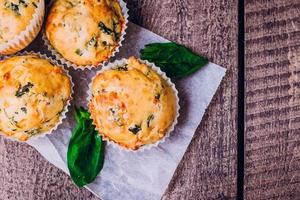 Muffins mit Spinat und Käse auf Holztischhintergrund. gesundes frühstückskonzept. foto