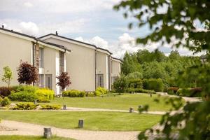 Reihe moderner Cottages. brandneue Reihe von Einfamilienhäusern. Modernes Design urbaner Wohnresidenzen mit privaten Innenhöfen, anspruchsvollen Oberflächen, Neuentwicklung. grüne Außenanlage, Liegewiese foto