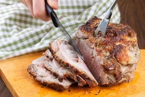 Gebackenes Schweinefleisch mit Gewürzen auf Holzschneidebrett foto