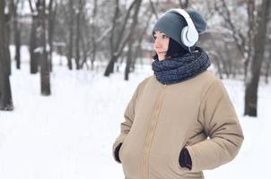 Winterportrait des jungen Mädchens mit Kopfhörern foto