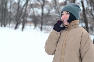 Winterporträt eines jungen Mädchens mit Smartphone foto