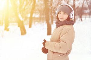 Winterportrait des jungen Mädchens mit Kopfhörern foto