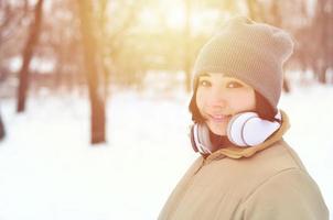 Winterportrait des jungen Mädchens mit Kopfhörern foto