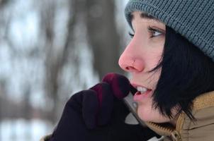 Winterporträt eines jungen Mädchens mit Smartphone foto