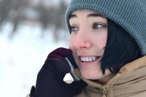 Winterporträt eines jungen Mädchens mit Smartphone foto