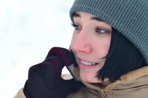 Winterporträt eines jungen Mädchens mit Smartphone foto
