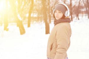 Winterportrait des jungen Mädchens mit Kopfhörern foto