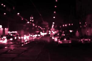 verschwommene Landschaft der Nachtstadt. Bild getönt in Viva Magenta, Farbe des Jahres 2023 foto