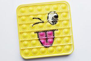 Pop it Zappelspielzeug. Mehrfarbiges Anti-Stress-Spielzeug mit Flügelform auf weißem Hintergrund foto