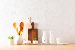 schöne moderne hintergrundküchenarbeitsplatte mit verschiedenen küchenutensilien zum kochen und zimmerpflanzen in keramik-mini-töpfen. foto