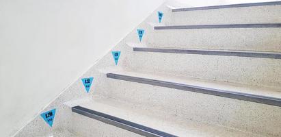 schwarze Zahl und blaues Zeichen für Kalorienverschwendung, wenn Menschen Treppen oder Treppen hinauf- und hinuntergehen. gesundes pflege- und bewegungskonzept. weiße Marmortreppe oder Innenarchitektur und Material verwenden. foto