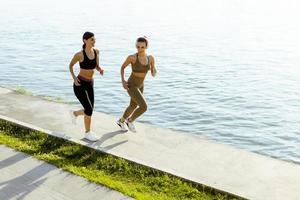 junge Frau beim Lauftraining an der Flusspromenade foto